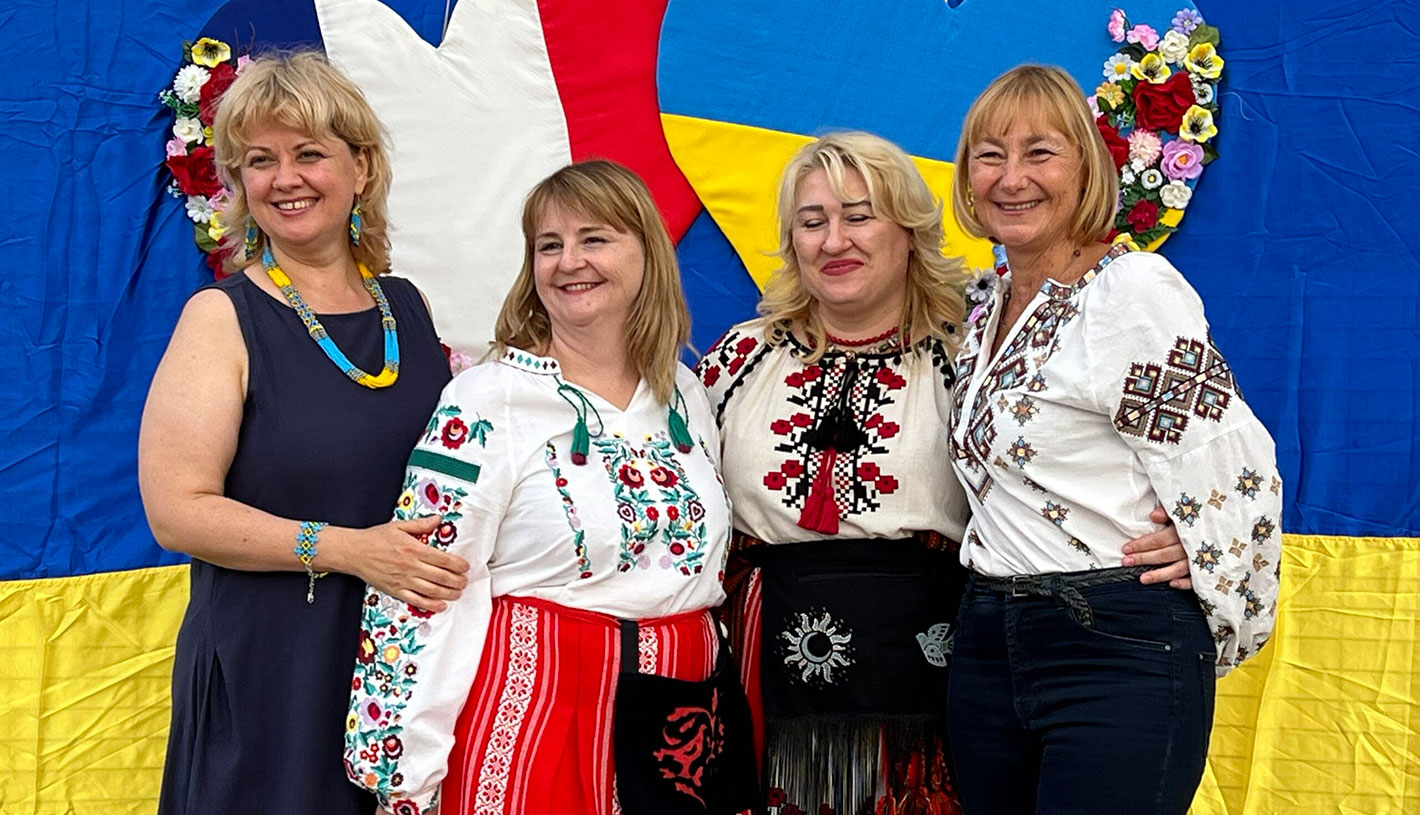 Des Ukrainiennes en vychyvankas devant le drapeau ukrainien