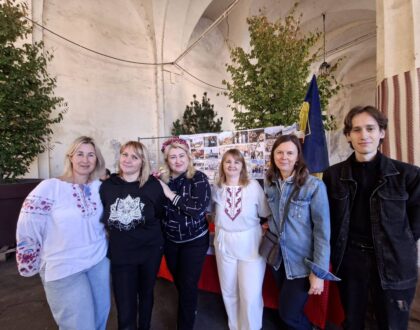 Six membres d’Ukraine-Lorraine posent ensemble sous les arcades, devant le stand de l’association