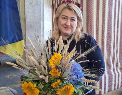 Bénévole d’Ukraine-Lorraine avec un bouquet de tournesols et d’épis de blé au stand de l’association